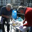 Voorzitter Ed Braad (l) en onze buurman Laurens wrikken de verse oesters open