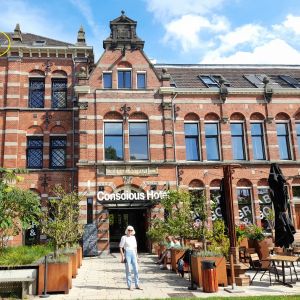 Anna voor het Conscious Hotel Westerpark. Rechstboven (gele cirkel) onze kamer.