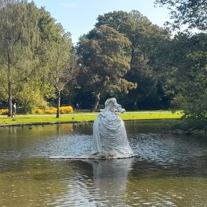 De drijvende bruidsjurk in de vijver achter het Conscious Hotel Westerpark. Er zit een duif  bovenop