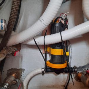 De afvoerslang voor de wasmachine is wit en na de nieuwe pomp (geel en zwart) doorzichtig.