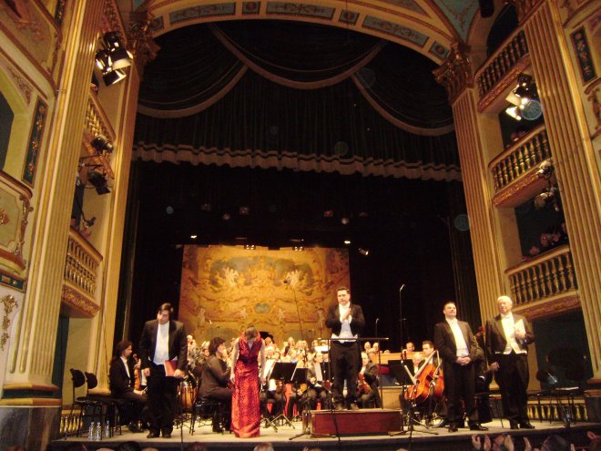 Applaus voor dirigent, solisten, koren en orkest in Manoel Theatre. Let op de scharlakenrode robe van Philippa Hyde