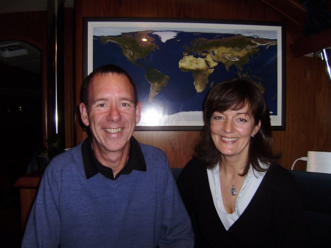 Sandra en Chris Mennem op hun Deep Blue. Achter die mooie wereldkaart zit een breedbeeld televisie