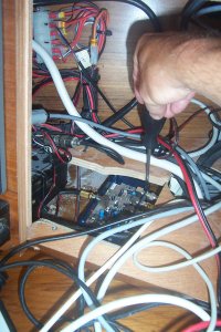 Hier zie je achter het paneel in de navigatiehoek. De schroevendraaier wijst naar het kastje van de Renaud Antenne. Links zie je de hoofdantenne die naar de mast loopt. Daarin zat uiteindelijk het probleem,  een eind verder bij de zwanehalsdekdoorvoer