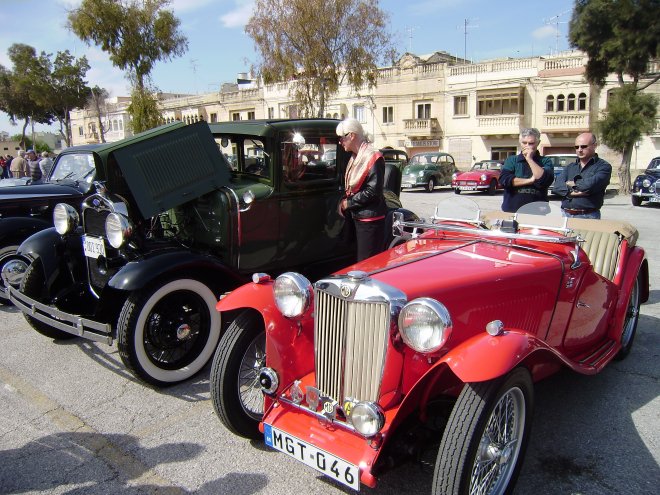 Ans tussen een oude Ford en een MG, op het marktplein van Zejtun