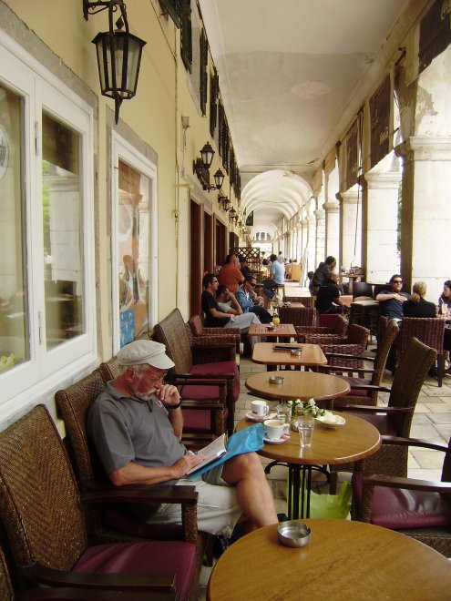 Onder de arcaden van een koffiehuis studeer ik in de Griekse spraakkunst
