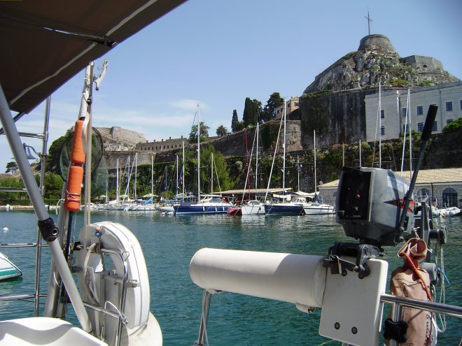 Mandraki Marina, uitzicht uit de kuip. Rechts op de wal het witgrijze gebouw van het Conservatorium. Daarboven het oude Venetiaanse fort. Links van het midden op de kade het restaurant waar we vanavond gaan eten