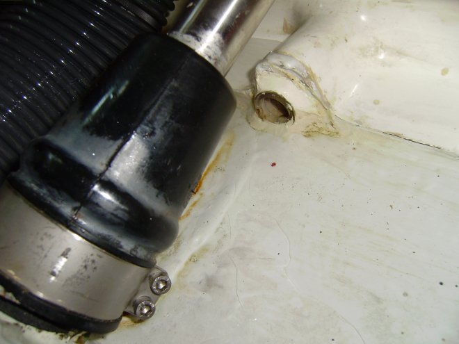 Dit is de afdichting van de schroefas. Een watergesmeerde afdichting. De boutjes linksonder zaten wat los maat vastschroeven hielp niet. Het lekwater loopt weg door het gaatje iets rechtsboven het midden en wordt via een slang naar het bilgeputje gevoerd.