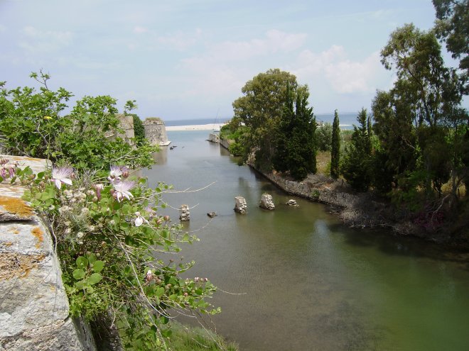 Ooit was dit de haven voor de galeien, onder de wallen van Fort Santa Maura, aan de noordelijke ingang van het Levkas Kanaal. het plantje op de voorgrond is volgens ons een Capparis Spinosa ofwel een Kappertjesstruik