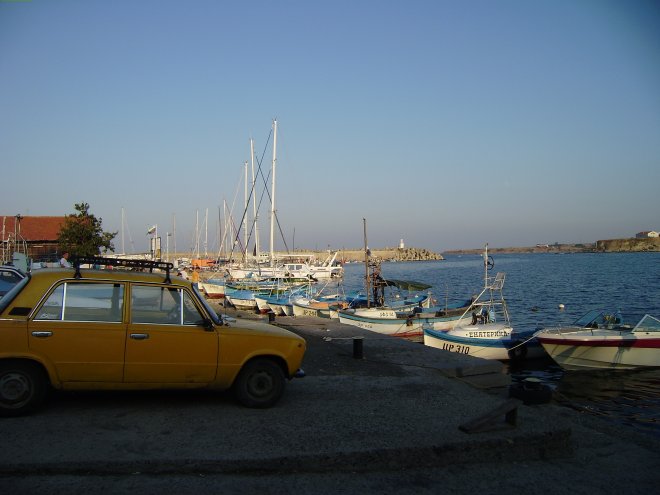 De haven van Tzarevo. De jachten liggen links van het midden. Een Lada op de voorgrond
