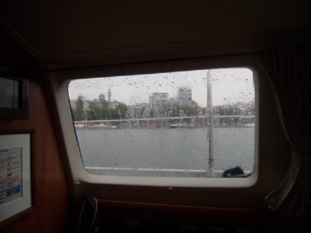 Regen. Door het raam zie je links door het venster de minaret en de koepel van de Mahmudiye moskee