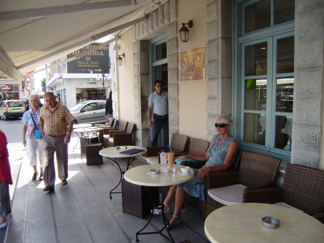 We drinken onze ochtendkoffie aan de veerhaven op de stoep van koffiehuis Asteria