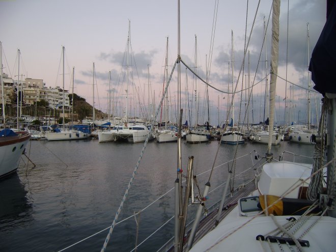 Marina Ayíos N. De ondergaande zon kleurt de hemel zacht rose en paars