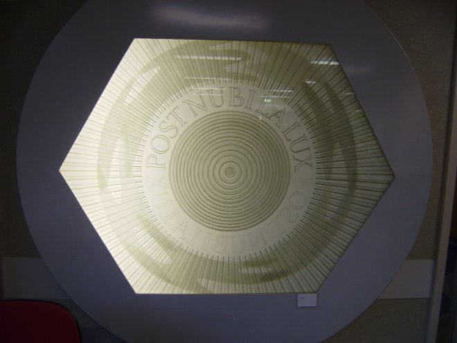 Het glaspaneel Post Nubila Lux in de hal van de polikliniek van het Beatrixziekenhuis in Gorinchem. Voor mijn gevoel is er rechts achter het paneel een lamp stuk