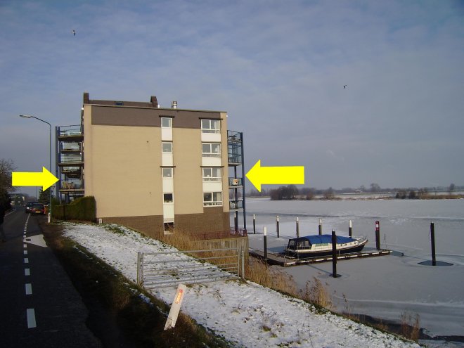 Hier wonen we, tussen de gele pijlen op de eerste etage aan de zuidzijde van De Oude Silo in Andel. Links de dijk, rechts de Andelse Maas