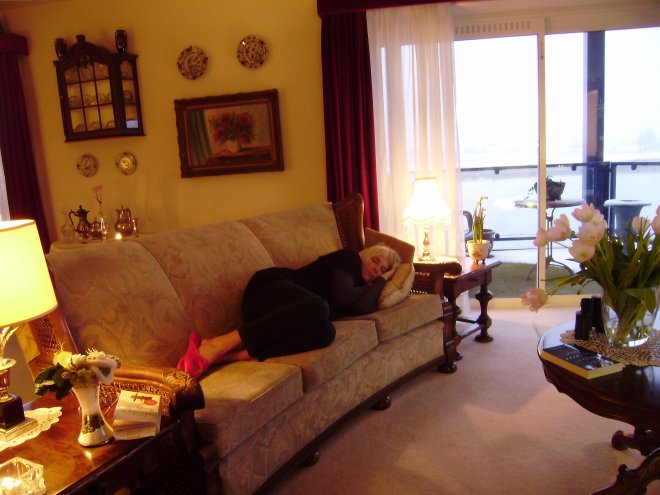 Ans slaapt op de bank temidden van de spulletjes van wijlen onze buurvrouw