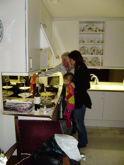 Ans, Barbara en Esri, drie generaties staan te koken in het keukentje van ons appartement