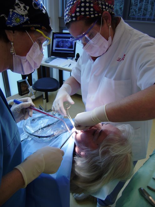 Kaakchirurge Louise Crisi hecht de linker onderkaak van Ans na het trekken van een klem zittende verstandskies