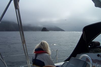 Kaap Finisterre in wolken gehuld. de kleine, zwarte rots ervoor is de Centolo de Finisterre