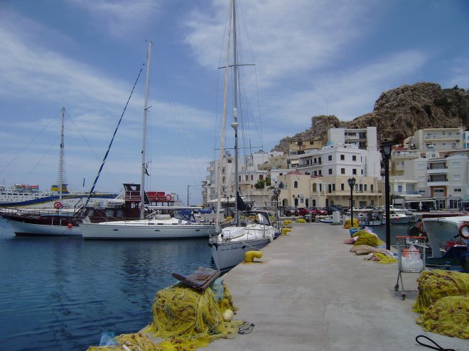 Afgemeerd aan de kade in Pigádhia op het eiland Kárpathos. Recht vooruit het sierlijke Ottomaanse pand van de havenpolitie