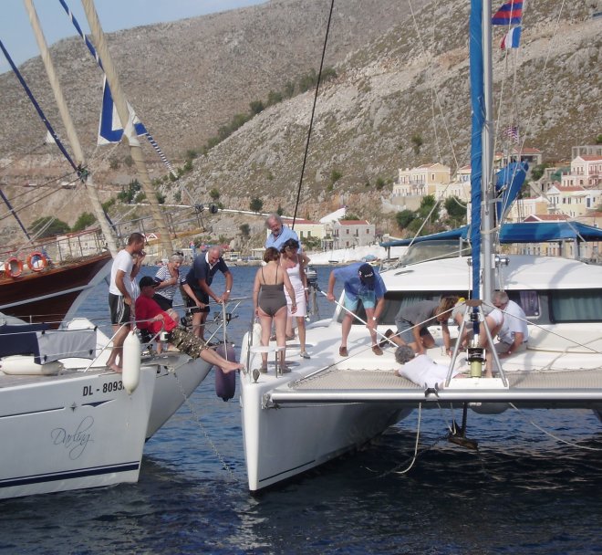 Gering ankerleed. Het anker van de catamaran heeft de ketting van het linker jacht geschept. De wind drijft hem ertegenaan. Met de pikhaak is het anker snel weer vrij
