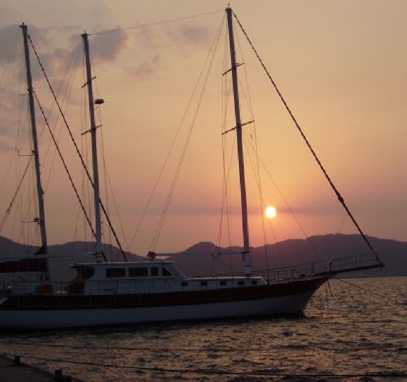 Koperkleurige zonsondergang achter een traditionele Turkse gulet aan de buitenkant van onze steiger in Marmaris Yacht Marina