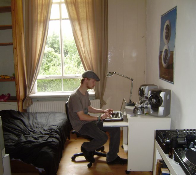 Bas op zijn nieuwe kamer in Wijk bij Duurstede. Hier componeert hij zijn muziek, aan de computer. Achter het raam een volledig verwilderde tuin (brandnetels)