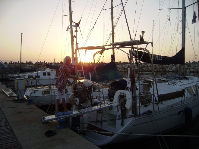 Ashkelon. Onze laatste avond kent een melancholieke zonsondergang. De buiskap en de bimini zijn eraf. Ans spuit nog eens de boot af