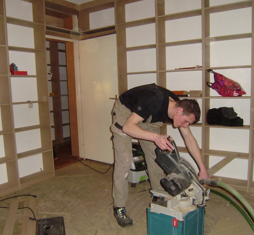 Peter bezig met zagen in mijn toekomstige studeerkamer. Let op de boekenkast boven de deur. Ik ben tuk op zulke details