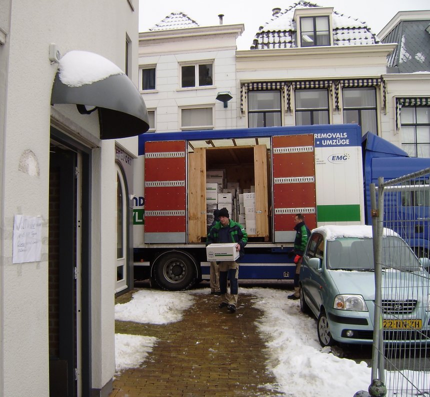 De verhuiswagen bij onze voordeur op het Eind. Je ziet in de wagen een van de twee kisten waarin onze boedel 3,5 jaar was opgeslagen. De eerste doos boeken wordt naar binnen gedragen