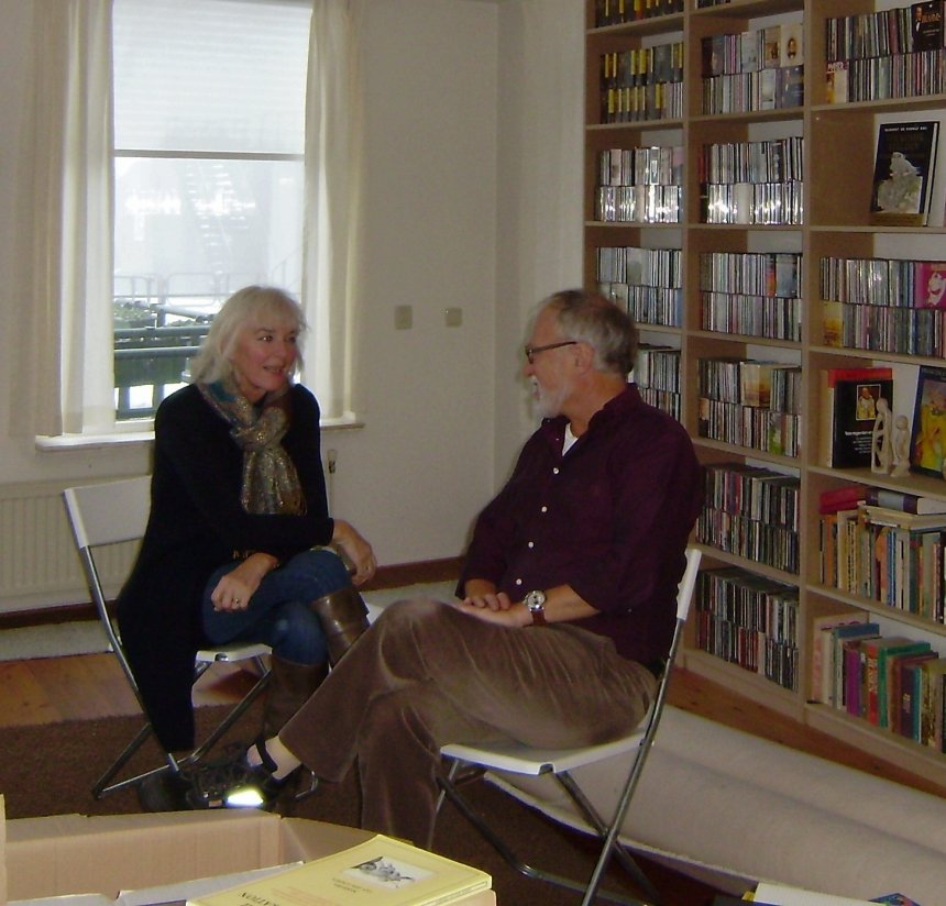 We drinken koffie in de woonkamer. Bijna alle boeken staan in de kasten