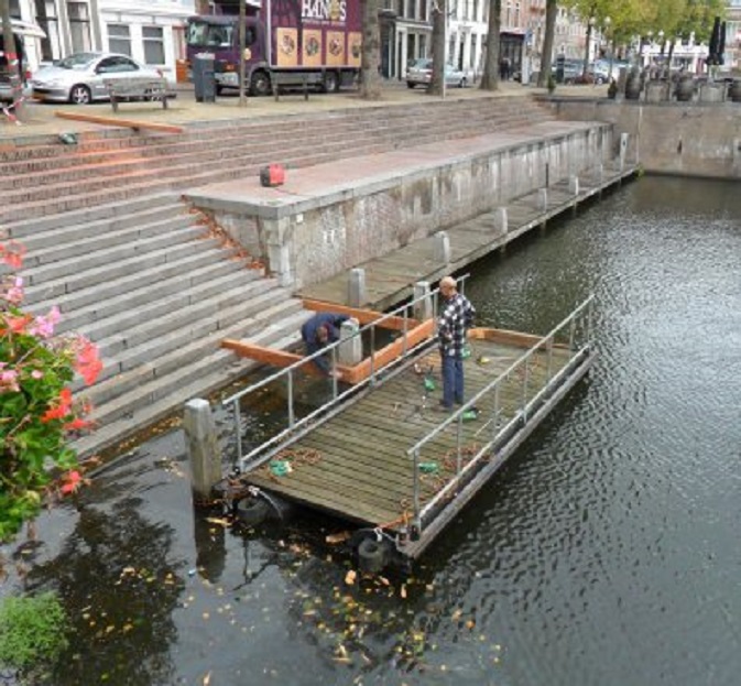 Voor ons appartement herstelt men een verrot stukje steiger