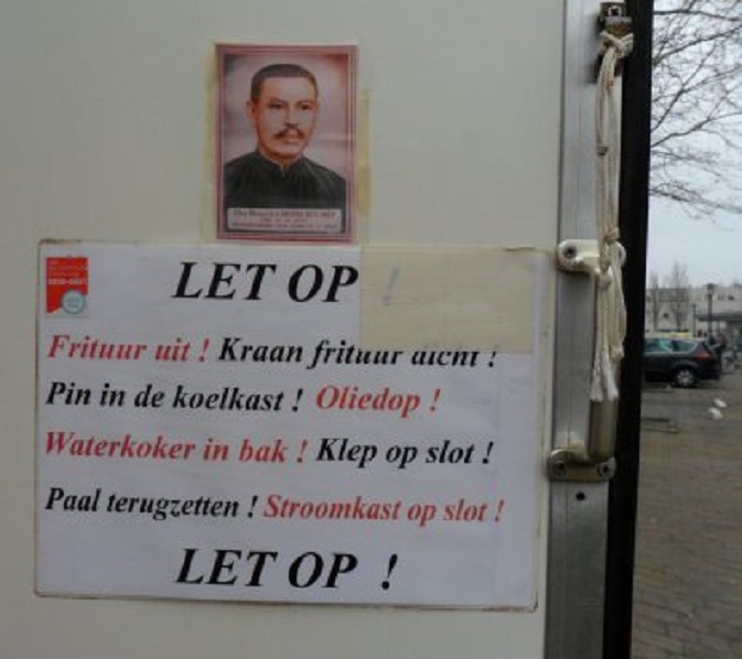 Papier met afbeelding van een heilige man op de binnenkant van de deur van het Vietnamese loempia karretje bij de Plusmarkt op Oost