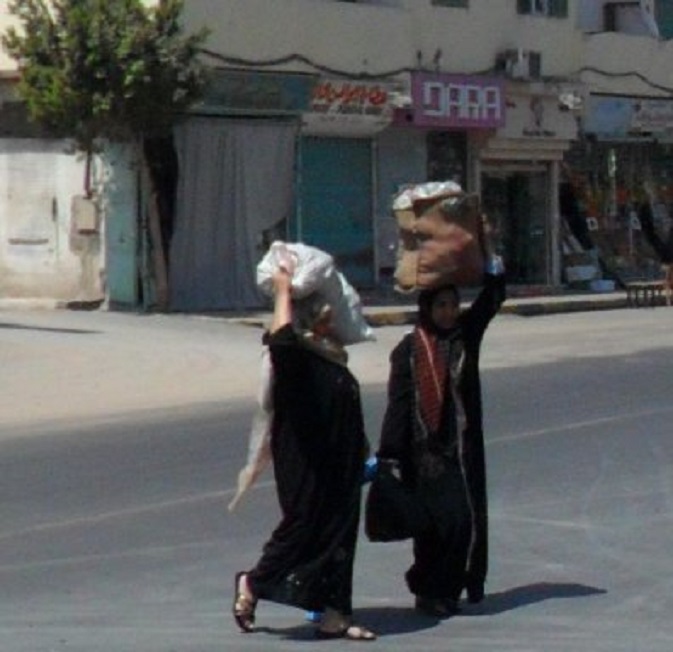 Twee vrouwen steken Sheraton Road over