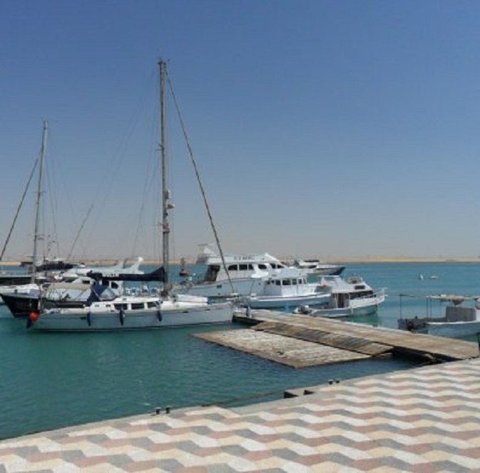 Dulce aan de steiger van de Suez Yacht Club (voordat ze gekeerd werd) Op de achtergrond het Suezkanaal, waar geen zeeschip vaart