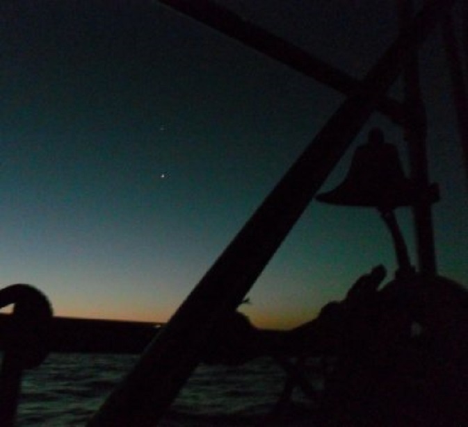 Eigenaardige configuratie van hemellichamen. Links van de scheepsbel zie je een heldere ster, recht erboven een minder heldere. De derde (bovenste) is niet te zien.