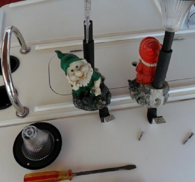 Op de kuiptafel lijm ik nieuwe kapjes op de zonnecelkabouters uit Malta