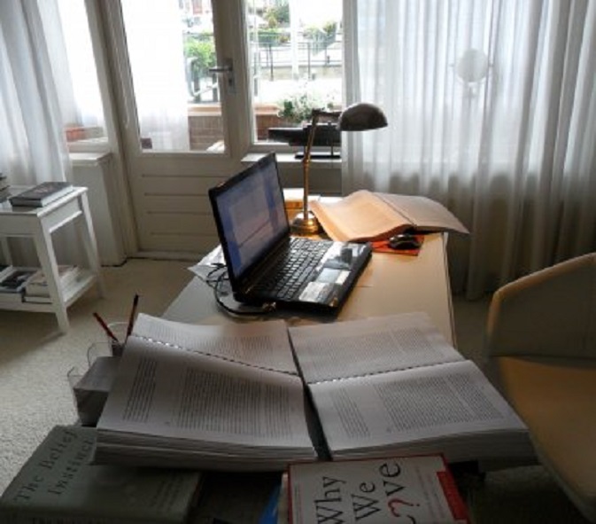 Mijn bureau met de drie opengeslagen correctieexemplaaren van mijn boek