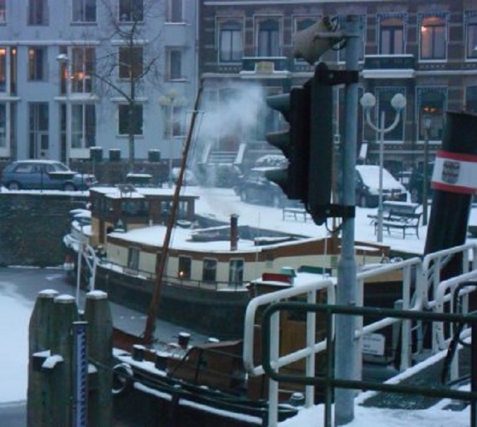 Rook uit het motoraakje in de hoek van de haven; de eigenaars zijn aan boord.