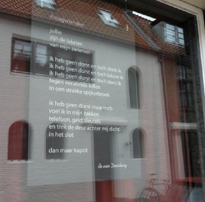 Het gedicht 'Kroegvrienden' van Ro van Doesburg op de ruit van Café De Keizer.