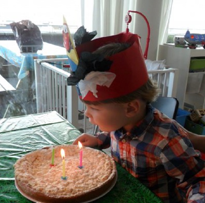 Kleinzoon Thijs - drie jaar geworden - blaast de kaarsjes uit