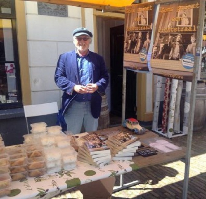 Kraamhouder voor mijn boek voor de deur van Wijnhuis Heukelum. Links de bakjes met zaziki, baklava en tappenades van de Griek (foto Annie Welbie)