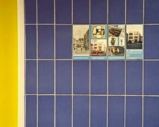 Herinneringstegels op het Bluebandhuis op de zijgevel in de Rosmolensteeg