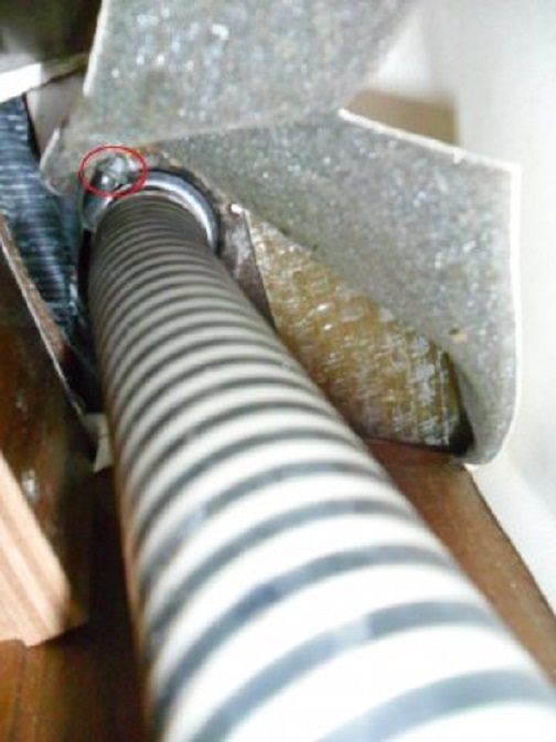 De vuldop van de voorste watertank van onderop. In de rode cirkel de slangklem