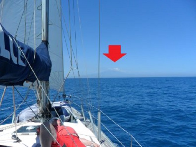 Op weg naar Catania. Wiger sluimert aan dek. Onder de rode pijl rijst de Etna op.