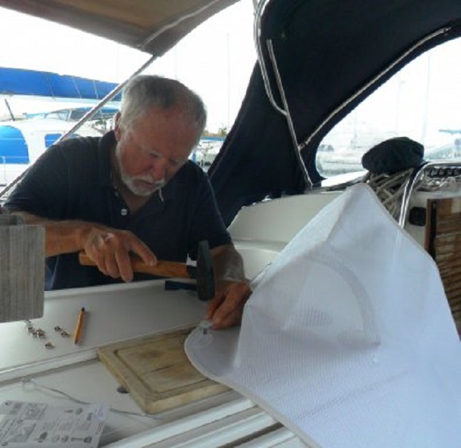 Bezig een gat voor een drukker in het UV-werend doek te slaan