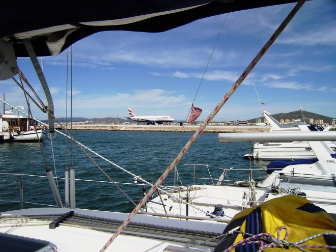 De dagelijkse British Airways vlucht uit Londen, van half twaalf is geland. De landingsbaan naast ons steekt diep de baai in.