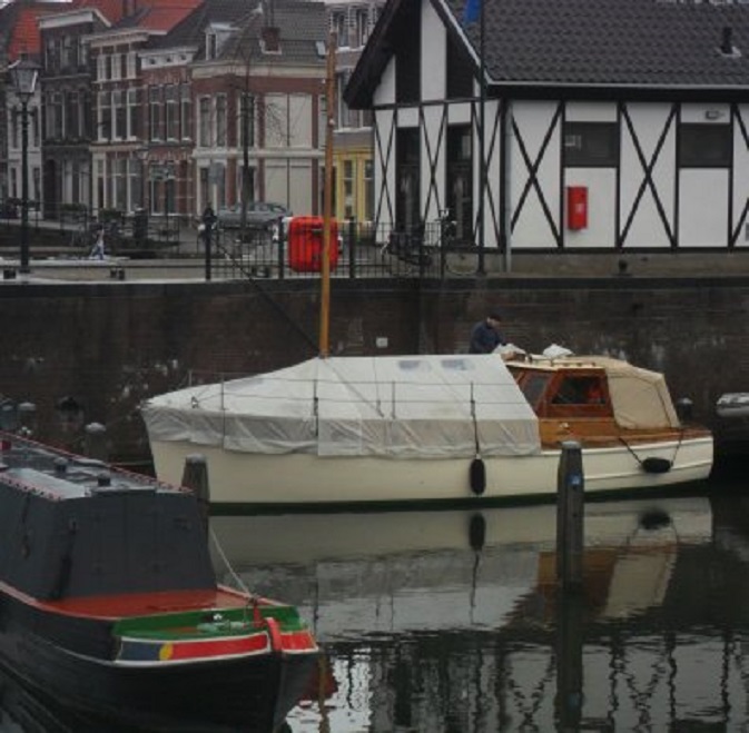 De zeiler van gisteren is bezig een afdekzeil over zijn boot te spannen. Het scheepje heet "Arctic Sunrise" en de thuishaven is Arklow aan de oostkust van Ierland
