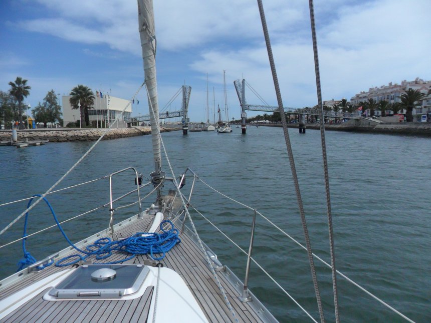 Tartaan vaart door de opening van de voetgangersbrug en wij er achteraan. Links is het havenkantoor