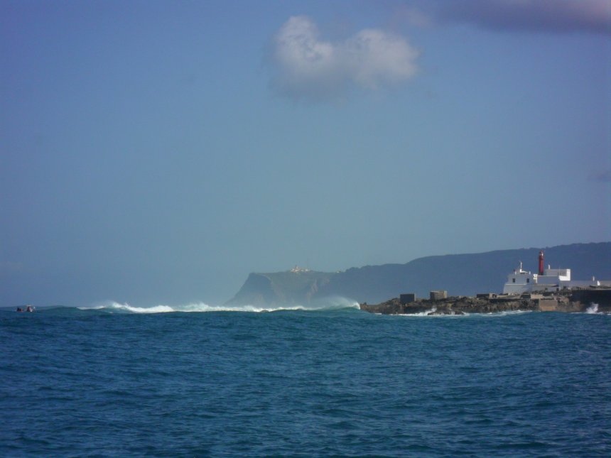 Brekers bij Cabo Raso, de lage kaap bij Cascais. Daarachter op ruim vier mijl Cabo da Roca, die veel hoger is.