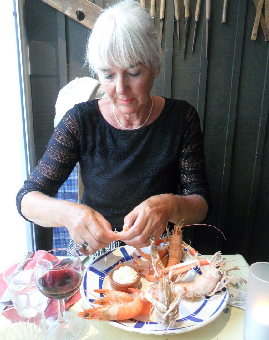Met een tang, een haakje en haar vingers ontleedt Ans de langoesten in Restaurant 'Le Tout du Cru'.
